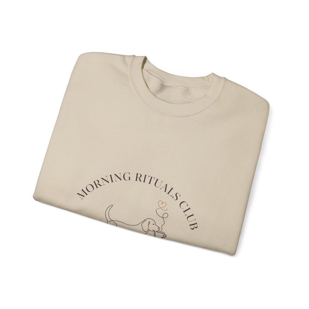Close-up of the dog and coffee cup print on a folded sand Morning Rituals Club crewneck