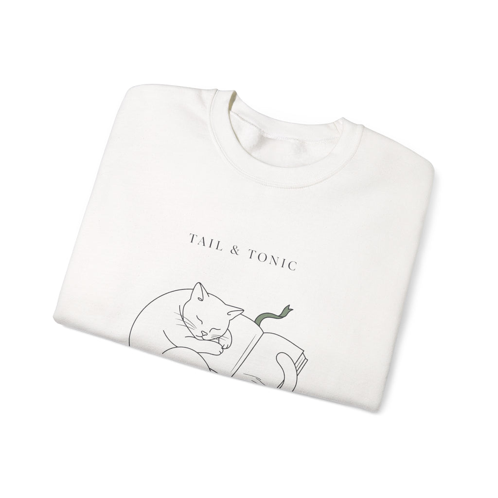 Close-up of the sleeping cat and book print on a folded white Quiet Company crewneck