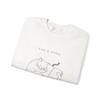 Close-up of the sleeping cat and book print on a folded white Quiet Company crewneck