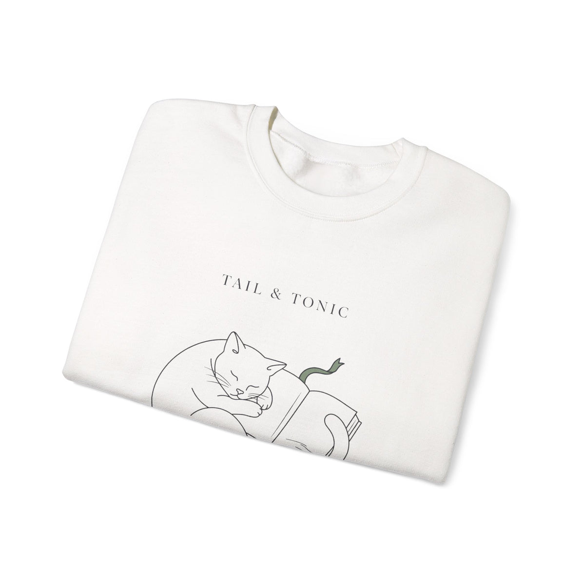 Close-up of the sleeping cat and book print on a folded white Quiet Company crewneck