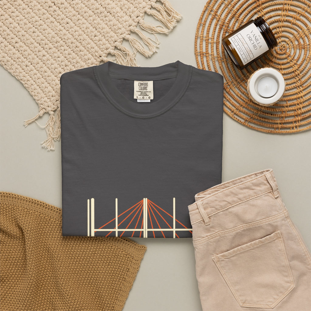 Shadow & Sunlight tee folded flat with a candle, jeans, and a woven placemat