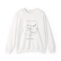 White Quiet Company crewneck with a line drawing of a cat curled up asleep on an open book, front view