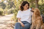 Lifestyle model mockup: woman wearing the white Companion Club tee with a golden retriever.